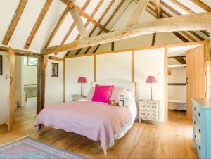 ein Schlafzimmer mit einem Bett in einem Zimmer mit Holzdecken in der Unterkunft The Oast House - Hartley Wine Estate in Alton