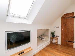 a living room with a large flat screen tv in a attic at The Rookery in Burford