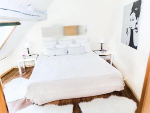 una camera da letto bianca con un letto bianco con cuscini bianchi di Ferienhaus Altes Nachtwächterhaus a Rühstädt