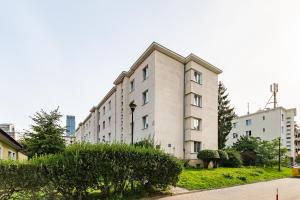 a large white building with bushes in front of it at Elektoralna 19A by Homeprime in Warsaw
