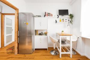 a kitchen with a stainless steel refrigerator and a table at Elektoralna 19A by Homeprime in Warsaw