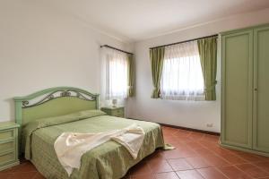 a bedroom with a green bed and two windows at Charming Small Villa - Bella villetta noi2082 in Cuile Pazzoni