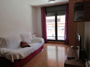 a living room with a white couch and a television at Pis a Bellpuig in Bellpuig