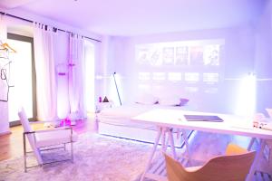 een witte kamer met een bed, een bureau en stoelen bij Cosy Apartment at Prenzlauer Berg with Terrace and HeadphoneCinema in Berlijn
