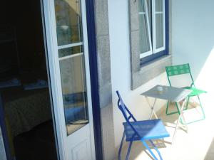un par de sillas y una mesa en el balcón en CoolHostel, en Oporto