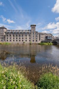 a large building next to a body of water at The Riverside in Kendal