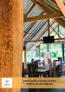 a dining room with a wooden table and chairs at Forestar Villa and Restaurant in Nittambuwa