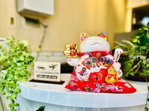 a figurine of a cat on a table with a laptop at My Kim Hotel - Ngay Bến Ninh Kiều in Can Tho +58 photos