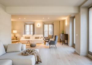 uma sala de estar com sofás brancos e cadeiras em Casa Fàbregas - Benestar Natural em Viladrau