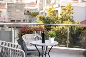a table with a bottle of wine and glasses on a balcony at Piccadilly House in Arta