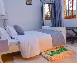 a bedroom with a bed with a rug on the floor at Savani Apartments, Kabale. in Kabale