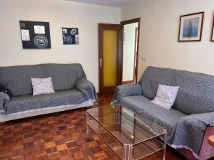 a living room with two couches and a glass table at Apartamento Isabel in Cuenca