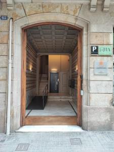 una entrada a un edificio con puerta de madera en Casa Lolita, en Barcelona