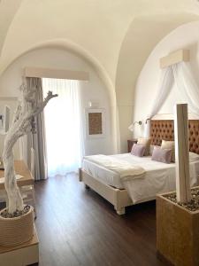 a bedroom with a bed and a large window at IL Borgo Relais in Gravina in Puglia
