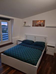 a bedroom with a bed with blue sheets and a window at F3 cosy - coeur nanterre- commerces et transports in Nanterre