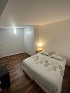 - une chambre avec un grand lit blanc et 2 oreillers dans l'établissement F3 cosy - coeur nanterre- commerces et transports, à Nanterre