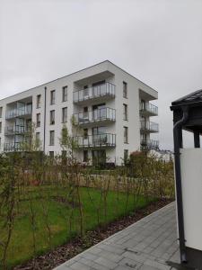 an apartment building with a garden in front of it at Luxus Apartament Bella in Gdynia