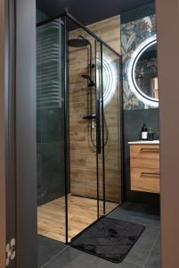 a shower with a glass door in a bathroom at Luxus Apartament Bella in Gdynia