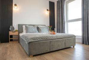 a large bed in a room with a large window at Luxus Apartament Bella in Gdynia