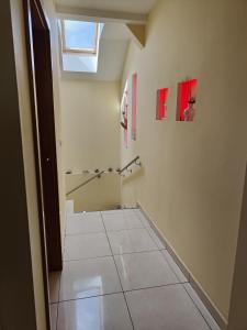a hallway with a tile floor and two pictures on the wall at Pensiunea Eli in Sibiu +20 photos
