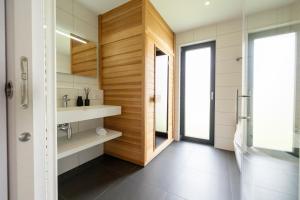 a bathroom with a wooden wall and a sink at Villas Winterberg in Winterberg