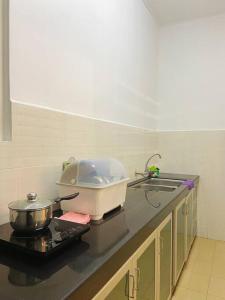 a kitchen with a sink and a pot on a stove at Homestay 2 @Taman Teluk Intan in Teluk Intan