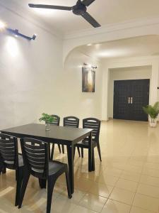 a dining room with a black table and chairs at Homestay 2 @Taman Teluk Intan in Teluk Intan