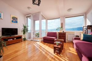 un salon avec un canapé violet et une télévision dans l'établissement Sun Spalato Hills 8, à Split