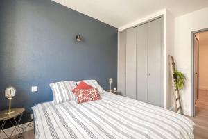 1 dormitorio con 1 cama grande y pared azul en Le Coursannais en Coursan