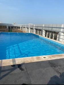 a large blue swimming pool in front of a building at Paradise Inn Jeddah Hotel in Jeddah +93 photos