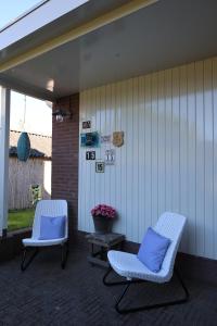 2 Stühle mit blauen Kissen auf einer Terrasse in der Unterkunft B&B nr.15 in Vries
