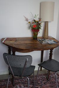 a table with a vase of flowers and two chairs at B&B nr.15 in Vries +16 photos