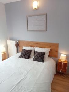 a bedroom with a large white bed with two pillows at Bel appartement proche gare et centre-ville in Rambouillet