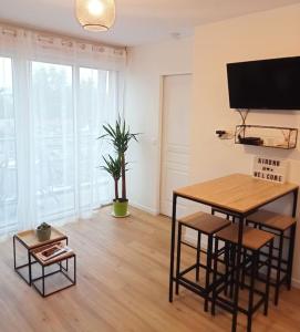 a living room with a table and a tv at Bel appartement proche gare et centre-ville in Rambouillet