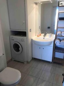 a bathroom with a sink and a washing machine at Bel appartement proche gare et centre-ville in Rambouillet