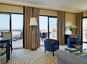 a living room with a couch and a table at Corinthia St George's Bay in St. Julianʼs