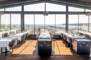 a restaurant with tables and chairs in a room with windows at Wyndham Grand Istanbul Kalamış Marina Hotel in Istanbul