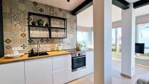 - une cuisine avec des placards blancs et une cuisinière dans l'établissement AA Guest - Mi Casa Eco Front Sea Views, à Mijas