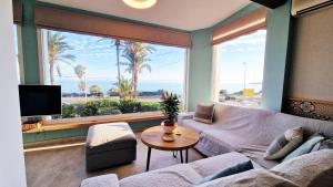 een woonkamer met een bank en een groot raam bij AA Guest - Mi Casa Eco Front Sea Views in Mijas Costa