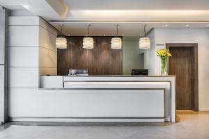 a reception desk in a lobby with flowers at NH Lisboa Campo Grande in Lisbon