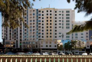 un gran edificio con coches estacionados frente a él en NH Lisboa Campo Grande, en Lisboa