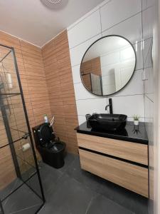 baño con lavabo negro y espejo en דירת אירוח מפנקת בעיר אשקלון - 5 דקות נסיעה מהים en Ashqelon