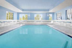 a pool in a hotel with chairs and tables at Homewood Suites by Hilton Portsmouth in Portsmouth