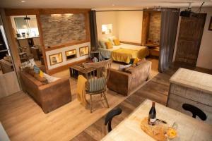 a living room with a bed and a couch at Le Bonheur En Beaujolais - pour 26 Personnes in Saint-Didier-sur-Beaujeu