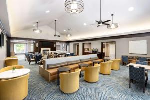 a lobby with yellow chairs and a waiting room at Homewood Suites by Hilton Portsmouth in Portsmouth