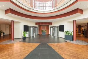 a large lobby with a domed ceiling and wooden floors at NH Dresden Neustadt in Dresden