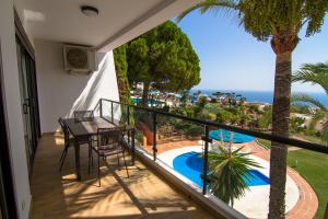 balcón con mesa, sillas y vistas al océano en Apartamentos & SPA Torres de San Juan, en Nerja