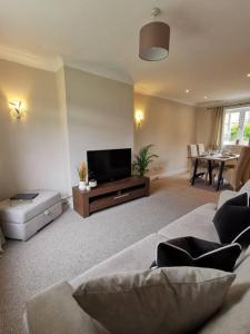 a living room with a couch and a flat screen tv at Limekilns House in Clydebank