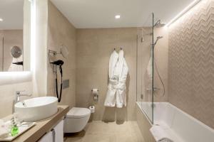 a bathroom with a sink and a toilet and a shower at NH Collection München Bavaria in Munich