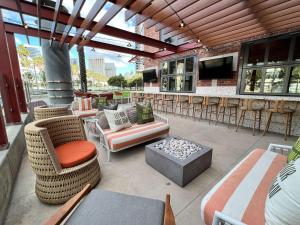 eine Terrasse mit Sofas, Stühlen und einer Feuerstelle in der Unterkunft Hilton San Diego Gaslamp Quarter in San Diego